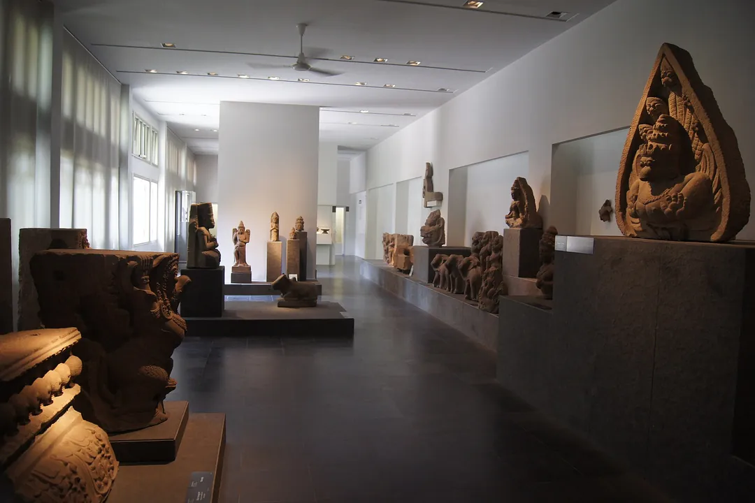 A dim gallery of carved Champa sandstone sculptures