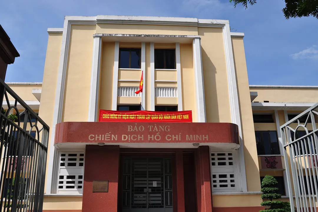 The yellow entrance building of the Ho Chi Minh Campaign Museum with its red sign