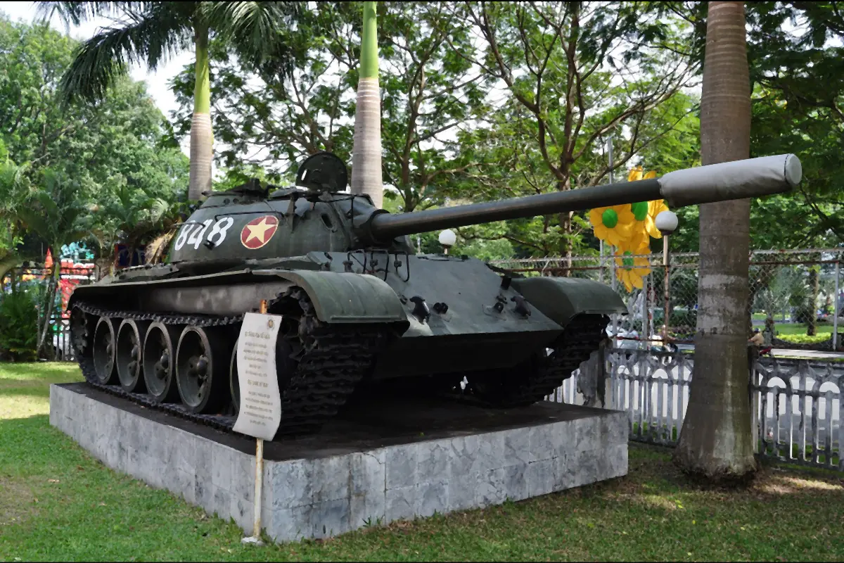 T-54 tank number 848 on a stone plinth among trees