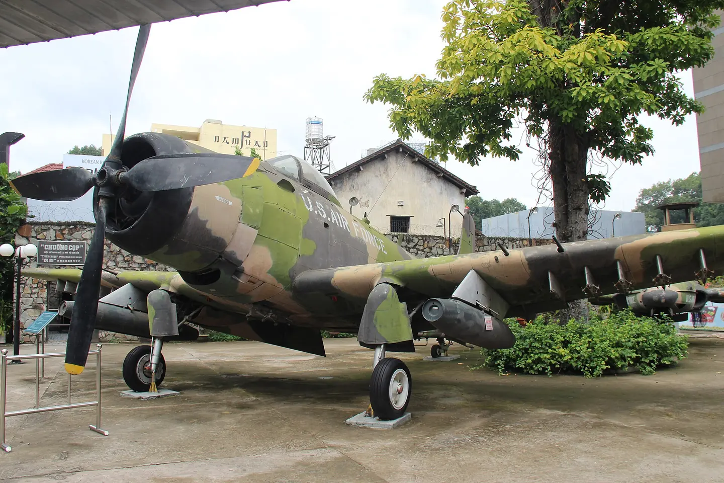 A camouflage-painted A-1 Skyraider propeller plane in the War Remnants Museum yard