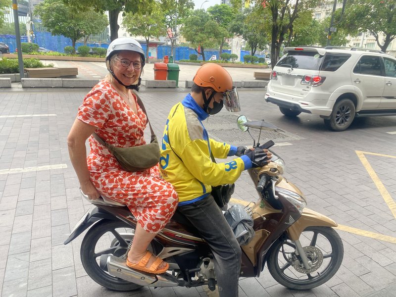 A smiling guest on the back of a motorbike taxi in central Saigon