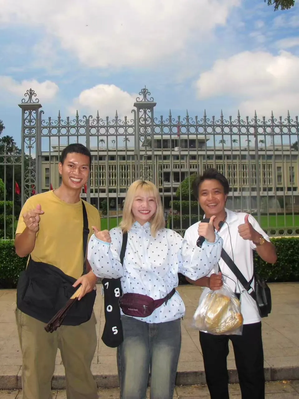 Three guests posing in front of an ornate palace gate