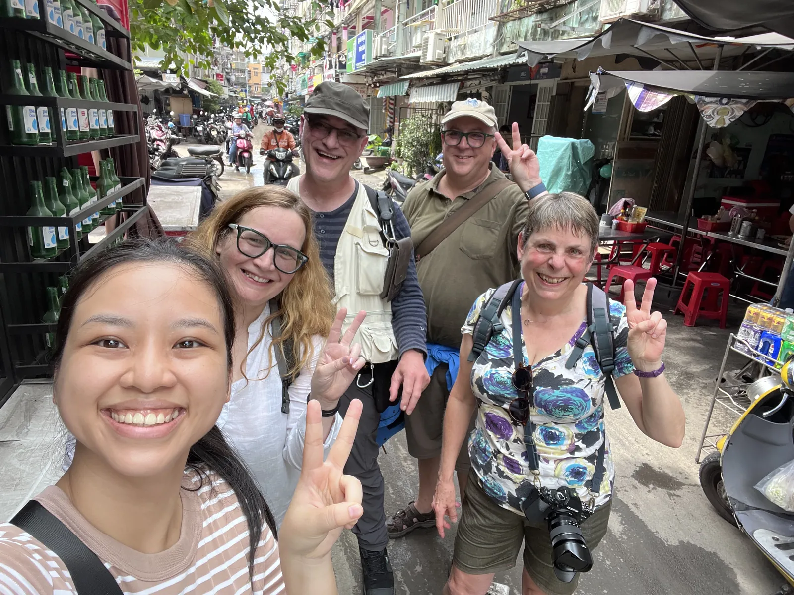 Five guests smiling together on a busy alley street