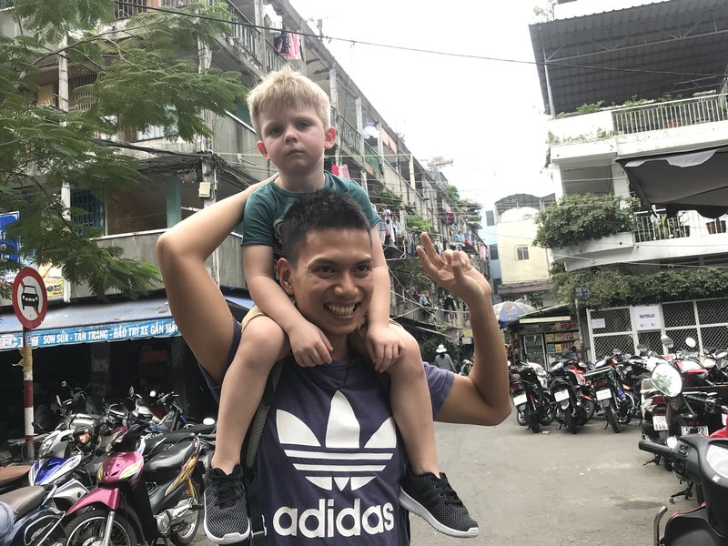 Our guide carrying a young guest on his shoulders on the street between the old apartment blocks