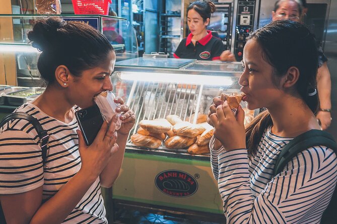 Women eating bánh mì on a Saigon street